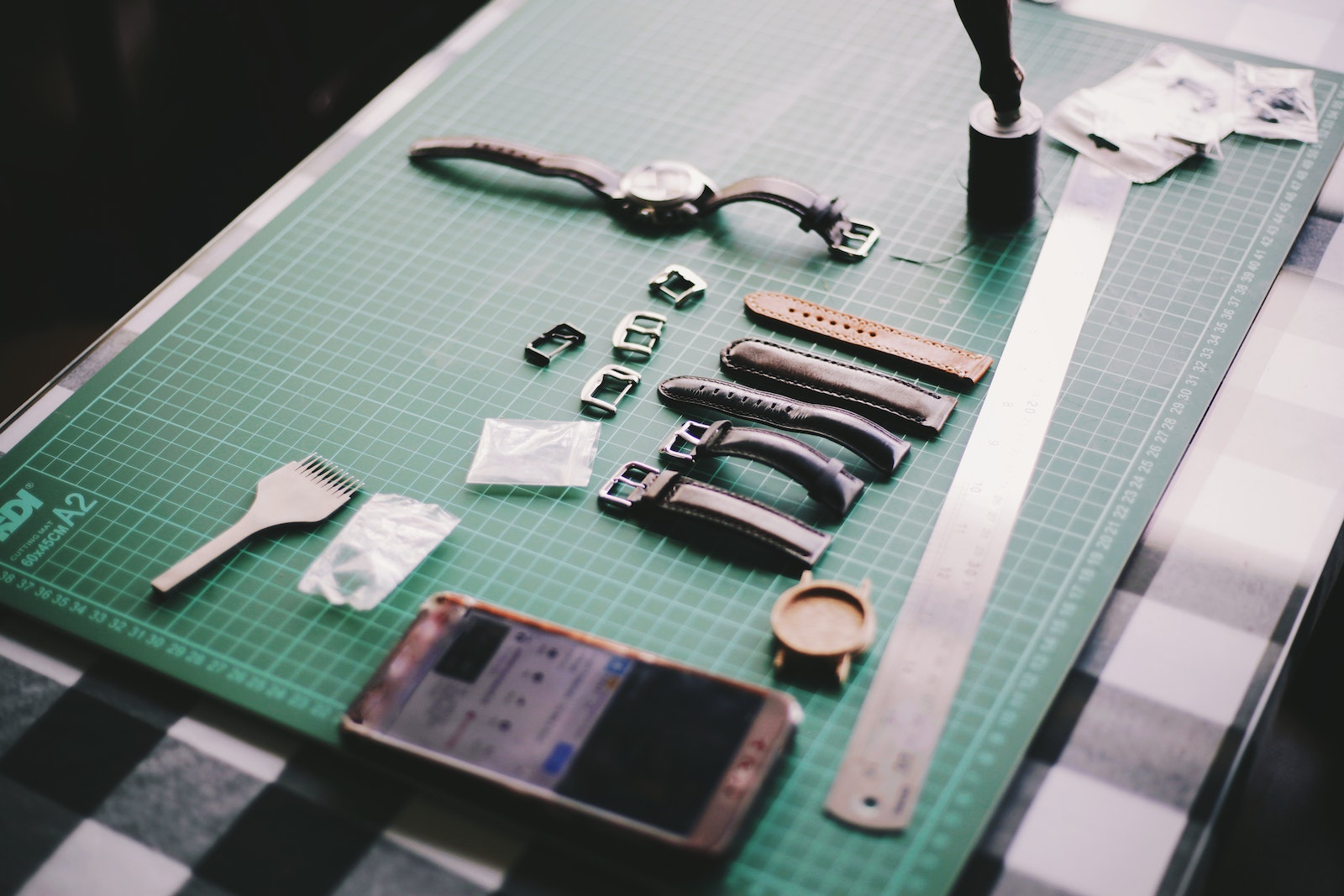 Watch With Straps Beside Smartphone on Table